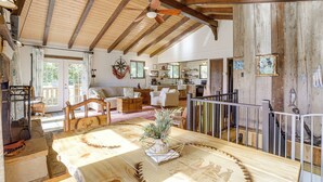 A spacious living area with a wooden ceiling, a dining table with a centerpiece, and a kitchen in the background. - Breathtaking Lake Views Walk to Alpine Lake (Terra Alta)