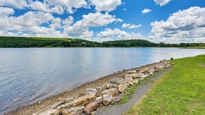 A calm lake with a stone wall and grassy banks. - Breathtaking Lake Views Walk to Alpine Lake (Terra Alta)