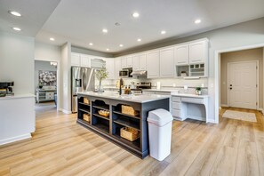 A modern kitchen with white cabinets, a central island, and built-in appliances. - Spacious Thornville Home ~ 8 Mi to Buckeye Lake! (Thornville)