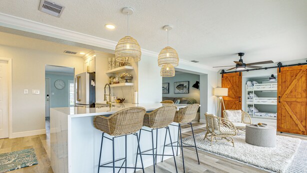 A modern kitchen with a central island, bar stools, and pendant lighting. - Private Fishing Dock: Waterfront Palmetto Home! (Palmetto)