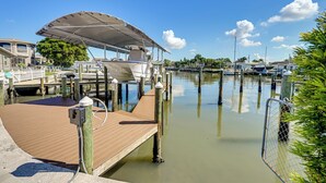 A marina with docked boats, a covered boat, and a wooden dock. - Private Fishing Dock: Waterfront Palmetto Home! (Palmetto)