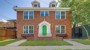 A two-story brick house with a green door, a small porch, and a fenced backyard. - 1 Mi to Dtwn, 8 Mi to Nrg! Fourth Ward Apt w/ W&D (Houston)