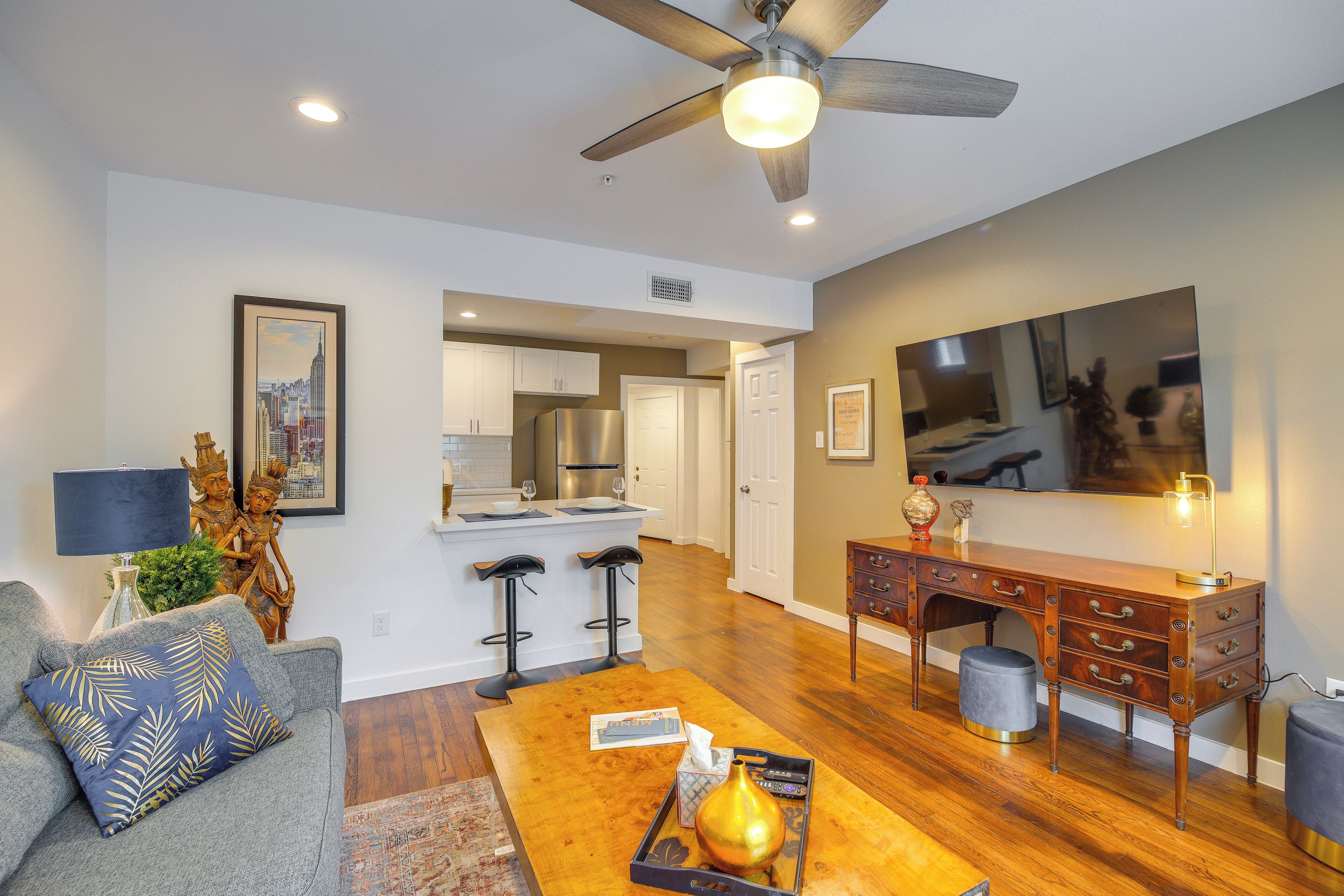 A modern living room with a sofa, coffee table, and a dining area with a wooden table and chairs.