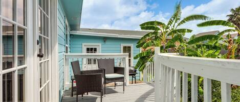 A covered porch with wicker furniture and a 'WELCOME' mat.