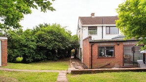 A residential property with a paved pathway leading to a brick house with a glass door and a small garden area. - Charming Retreat Near Grange Hill (Central Line) (Greater London)