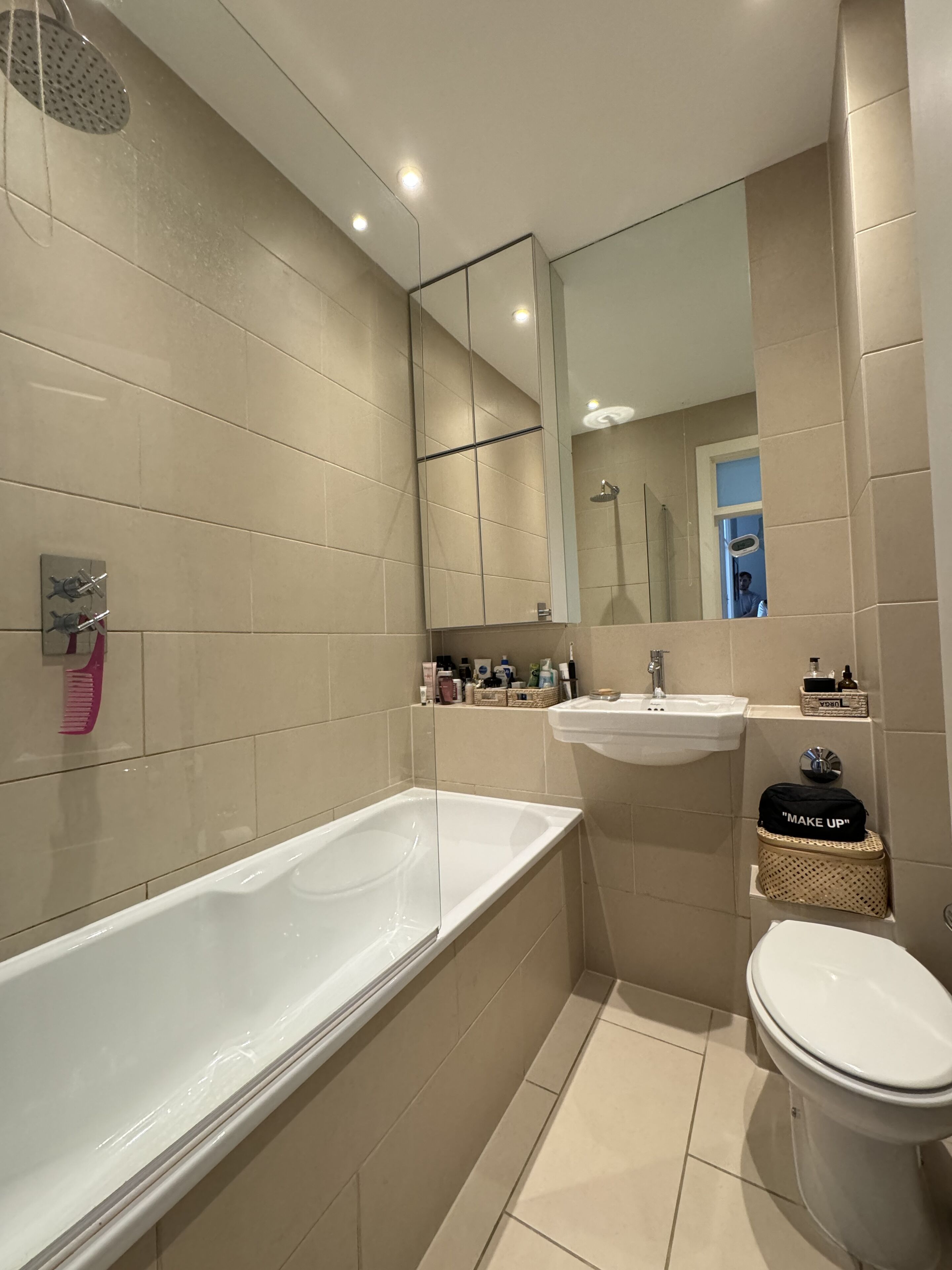 A modern bathroom with a large bathtub, a sink, and a toilet.
