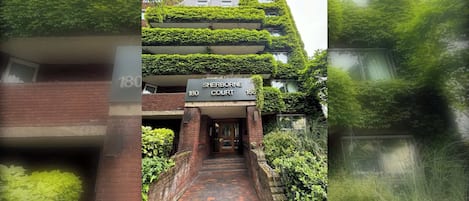 A building with a sign reading 'Sherborne Court' at the entrance, featuring a brick facade and a pathway leading to the door.