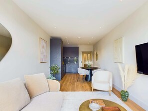 Ein modernes Wohnzimmer mit einer Couch, einem Couchtisch und einem Essbereich mit Tisch und Stühlen.