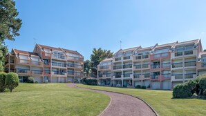 A multi-story residential building with a central courtyard, balconies, and a paved walkway. - Seaside. for 4 people. in Pornic (Pornic)