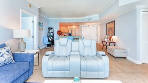 A living room with a blue sofa, a white armchair, and a coffee table. - Last Minute Rates! P4-1202 - 2B Portofino Island Views! (Pensacola Beach)