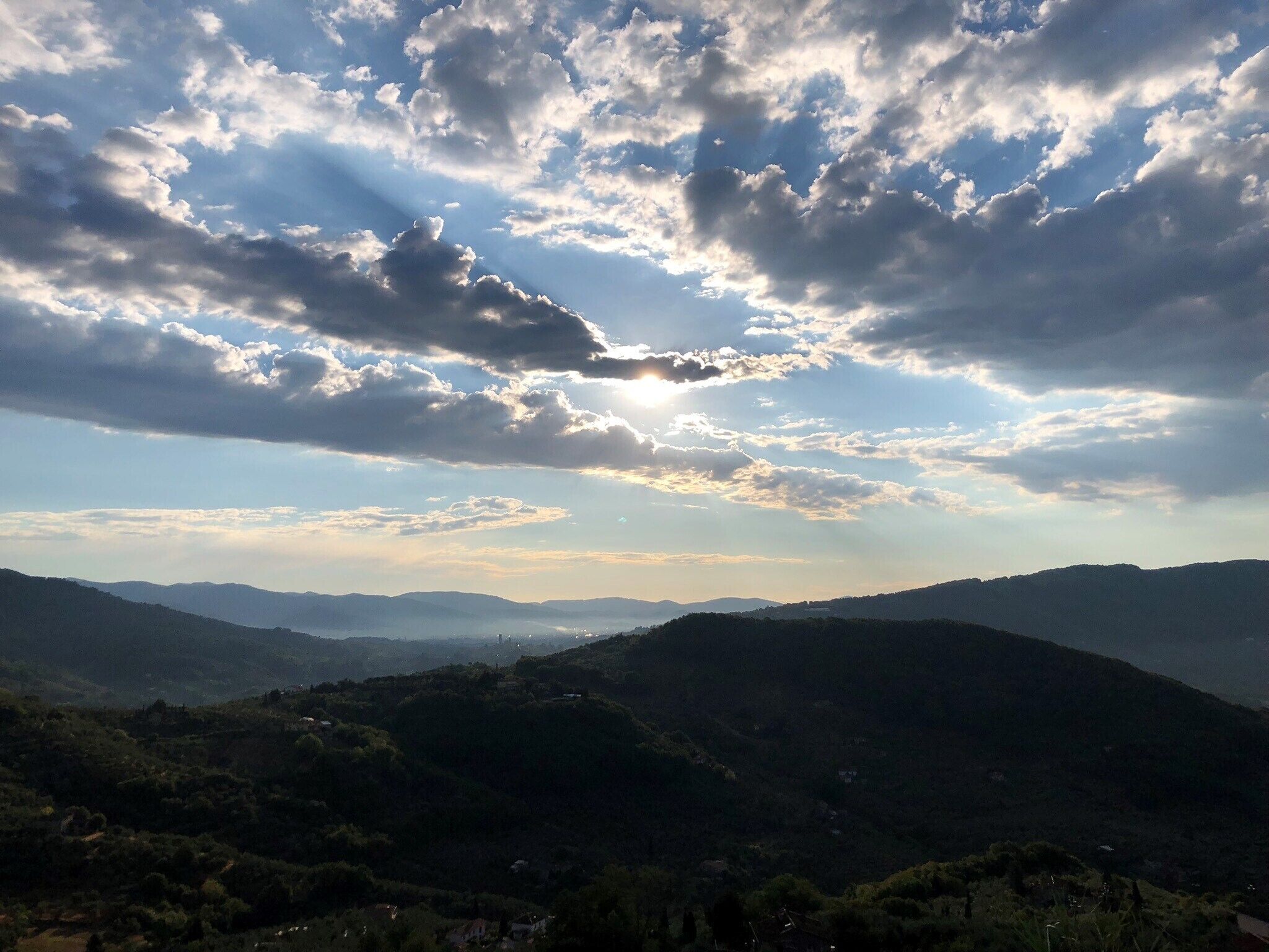 Un paysage montagneux parsemé de quelques nuages, sous un ciel dégagé.