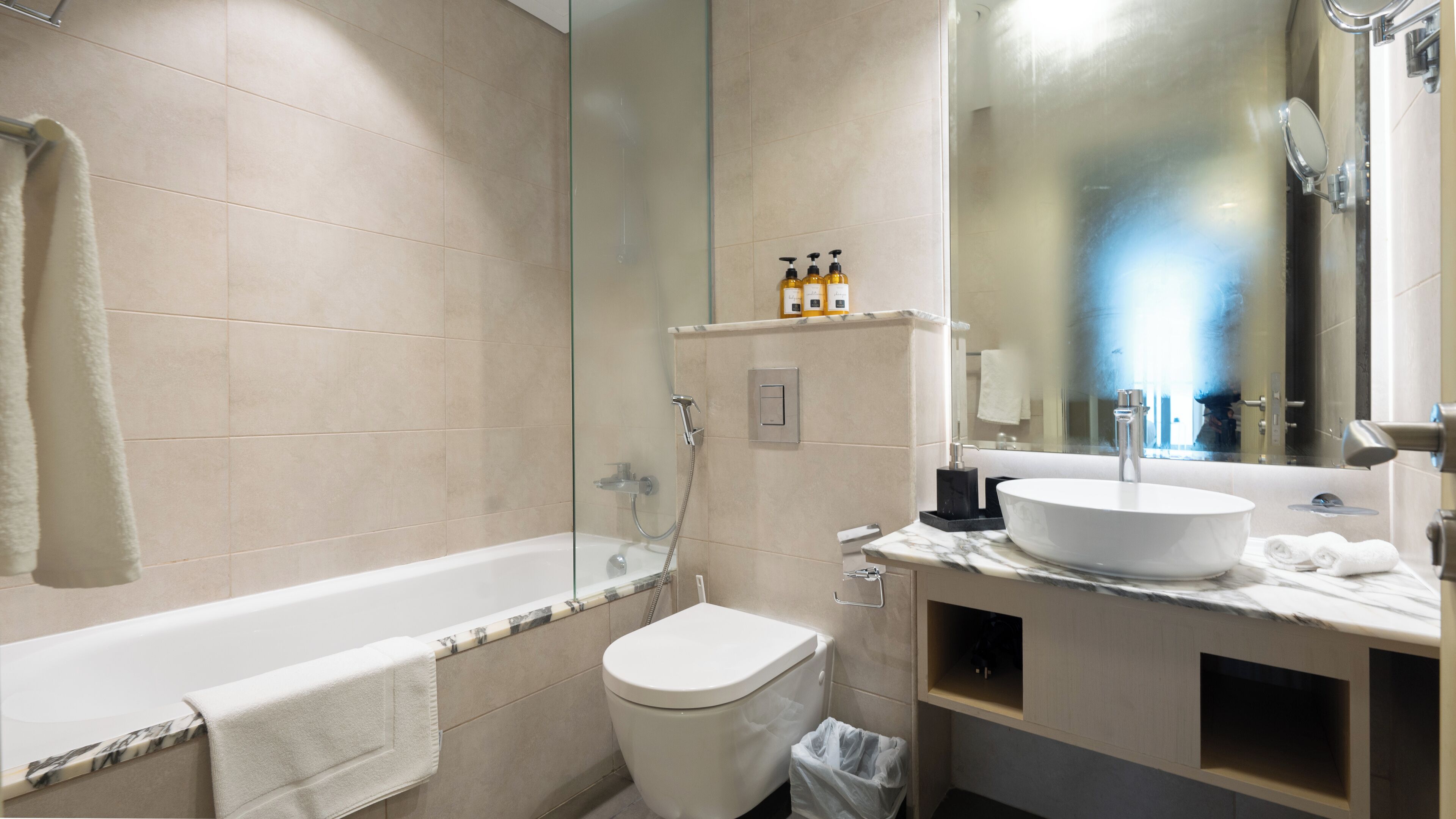 A modern bathroom with a bathtub, toilet, and sink.
