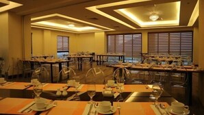 A dining area with tables set for a meal, featuring a modern ceiling design and large windows. - Hotel Monticello Tagaytay (Tagaytay)