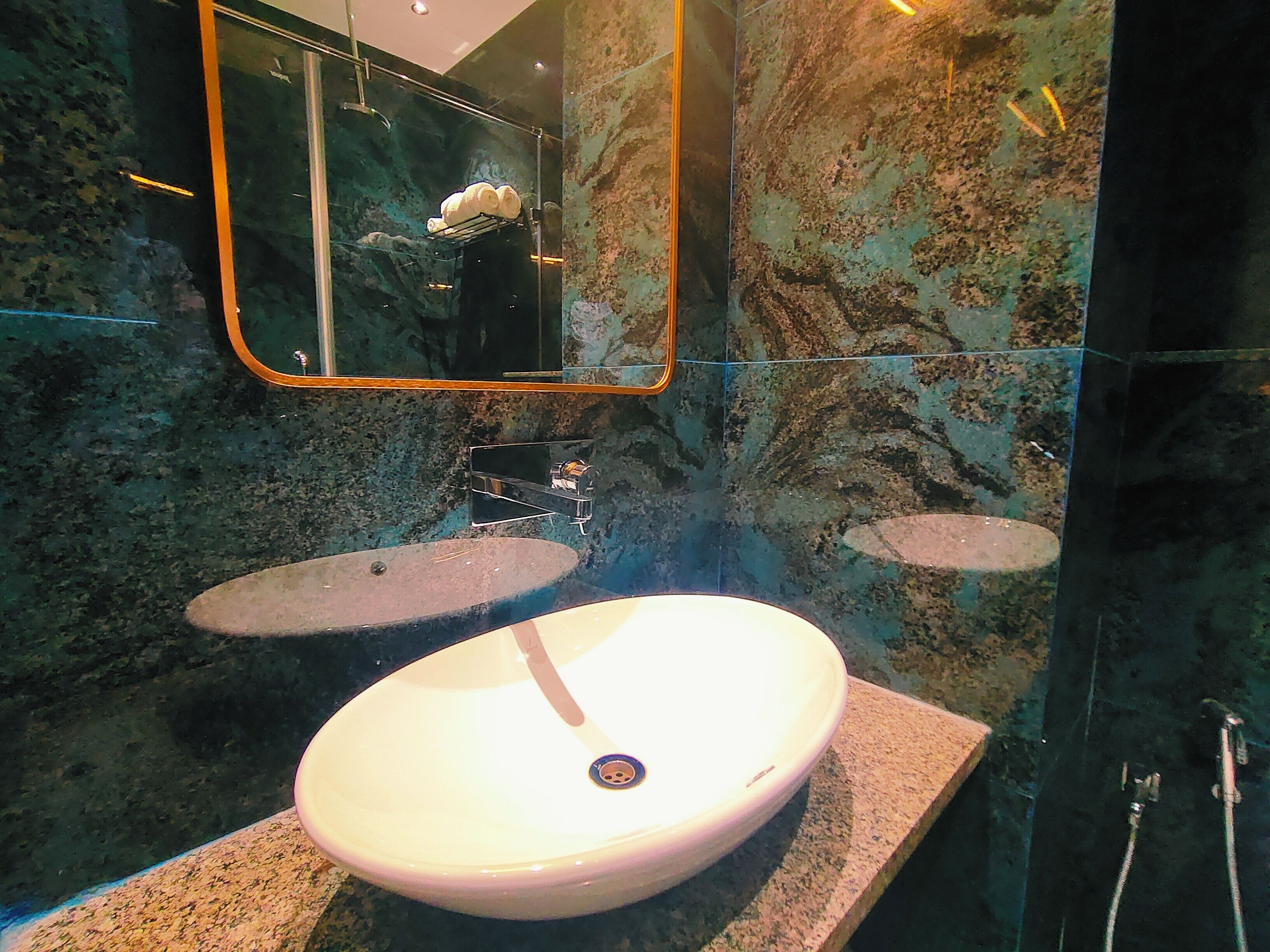 A bathroom with a white sink, a mirror, and a shower.