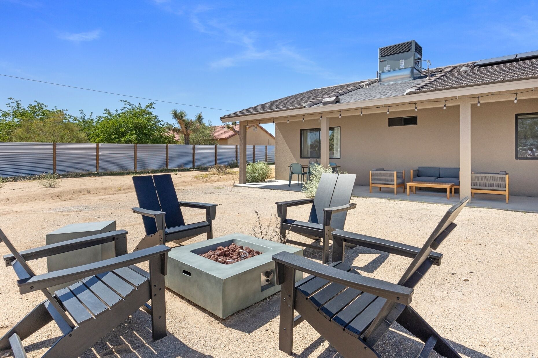 A patio with outdoor furniture, a fire pit, and a building with a tiled roof.