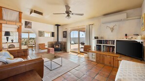A spacious living room with a fireplace, leather sofa, and a television.