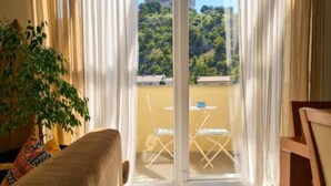 Un balcon donnant sur un espace verdoyant, avec une table et des chaises.