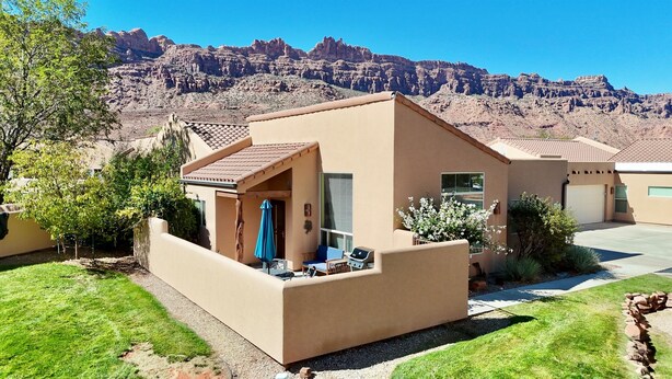 A single-story house with a patio, a barbecue grill, and a view of rocky mountains. - Pet-Friendly I Rim Village I Garage I Pool & Hot Tub I Trailer Parking (Moab)