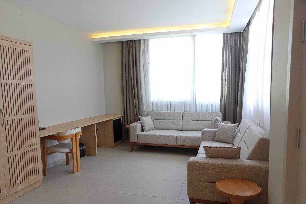 Een moderne woonkamer met een bank, een klein tafeltje en een houten kast.