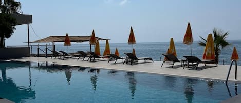 Piscine extérieure, parasols de plage, chaises longues