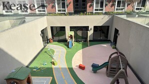 Un espace de jeux extérieur comprenant un toboggan, des structures d’escalade et un petit espace vert.