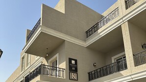 Un hôtel à plusieurs étages, doté de balcons, d’une façade en briques et d’une enseigne indiquant le numéro de chambre 125.