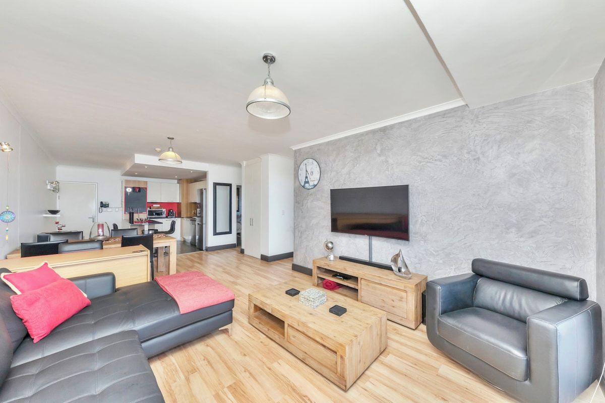 A modern living room with a sofa, coffee table, and TV.