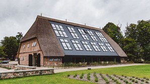 A building with a sloped roof and multiple windows. - Gut Damp (Damp)