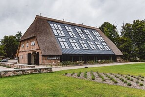 A building with a sloped roof and multiple windows. - Gut Damp (Damp)