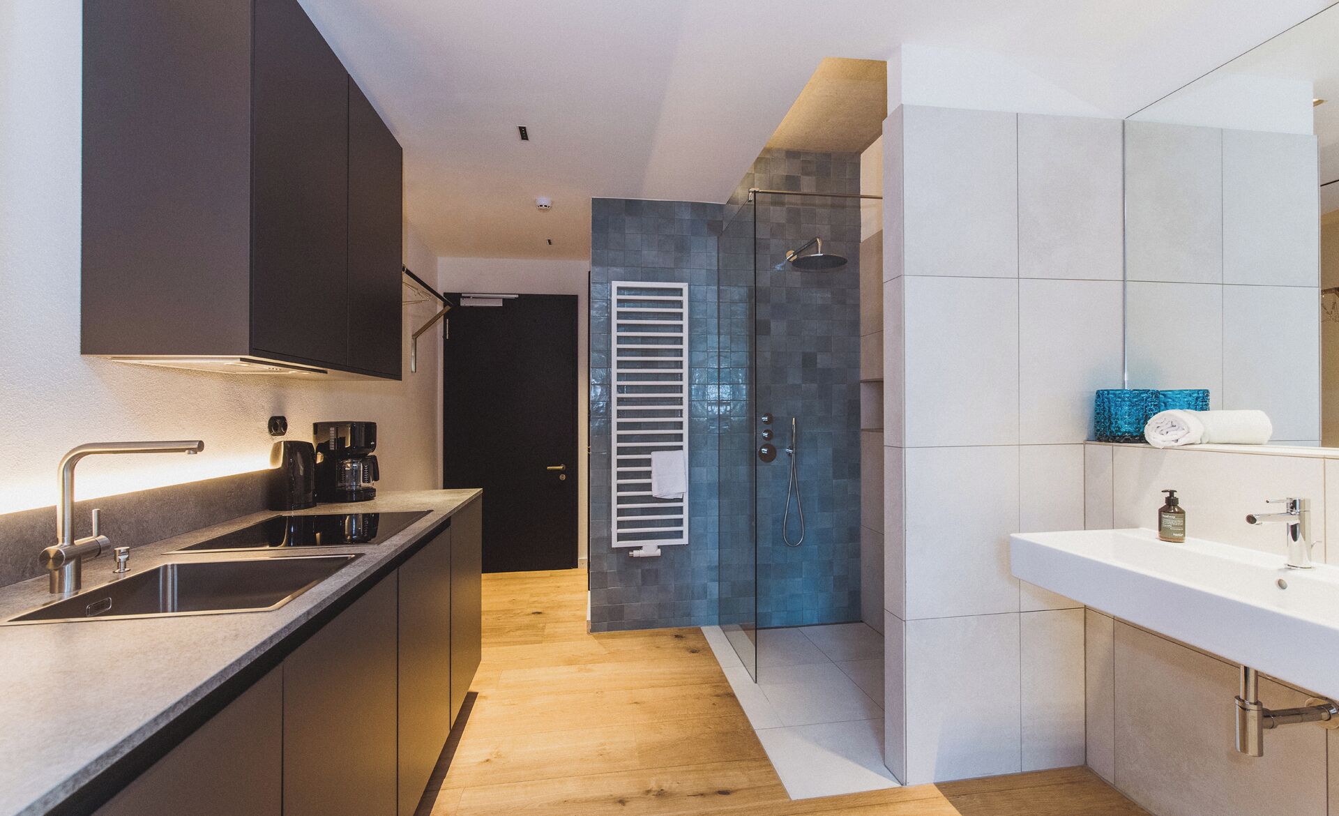 A modern kitchen with a built-in oven, a coffee maker, and a sink.