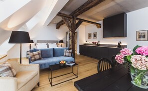 A modern loft apartment with a loft bed, a sofa, a dining table, and a kitchen area. - Gut Damp (Damp)