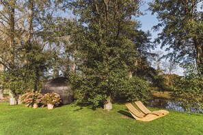 A garden with a wooden bench, a pond, and a wooden structure. - Gut Damp (Damp)