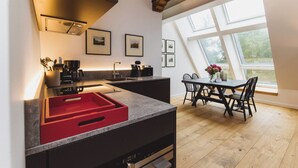 A modern kitchen with a dining area, large windows, and a view of the outdoors. - Gut Damp (Damp)