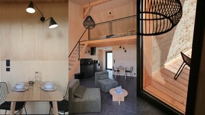 Et moderne interiør med spiseplads, køkken og opholdsområde med trappe.