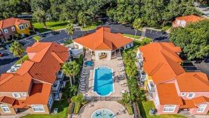 A residential area with multiple houses, a central swimming pool, and a circular water feature. - Family-Friendly Oasis near Disney and Theme Parks (Kissimmee)