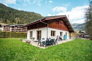 A wooden chalet with a patio area, surrounded by greenery and mountains. - Chalet 9 persons, near Linga gondola, with Wi-Fi - Chatel Reservation (Châtel)