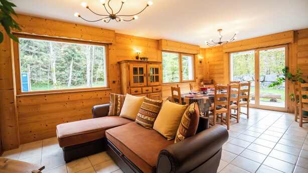 A cozy cabin interior with a sofa, dining table, and chairs. - Chalet 9 persons, near Linga gondola, with Wi-Fi - Chatel Reservation (Châtel)