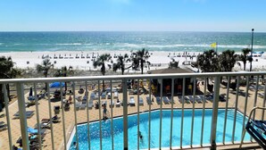 Vista a la piscina, con playa y océano al fondo.