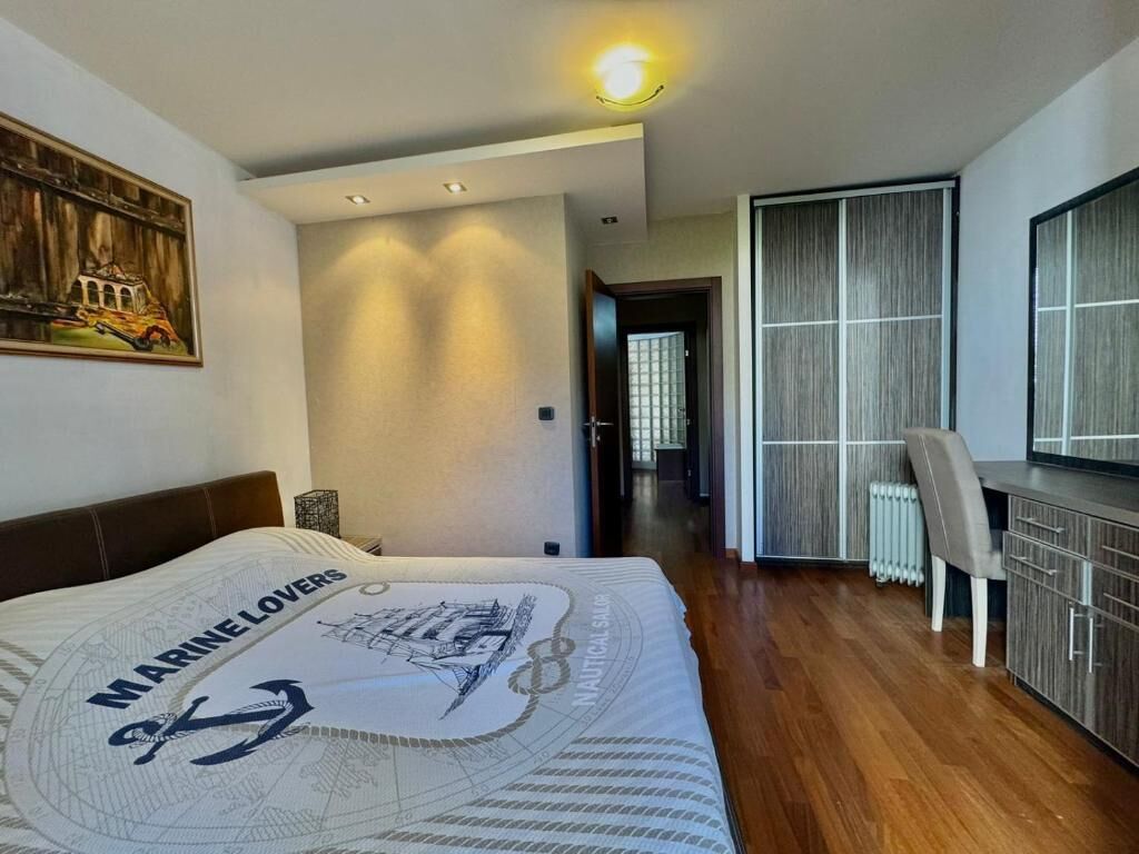 A bedroom with a bed, a desk, and a chair.