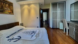 A bedroom with a bed, a desk, and a chair. - Family Two Bedroom Apartment Vasko (Budva)