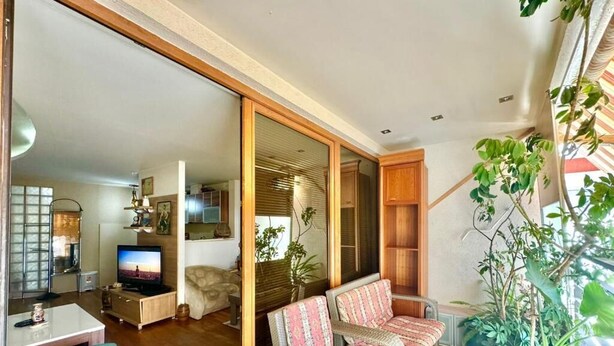 A living room with a sofa, a television, and a dining area with a table and chairs. - Family Two Bedroom Apartment Vasko (Budva)
