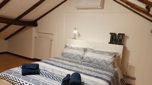 A bedroom with a bed, a nightstand, a lamp, and a radiator. - Casa Marzia: cosy, quiet, close to the centre and Sant'Orsola Malpighi Hospitals (Bologna)