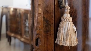 Een houten deur met een decoratief handvat en een sleutelhanger met kwast.