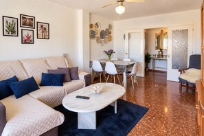 Un salon comprenant un canapé, une table basse et un coin repas avec des chaises.