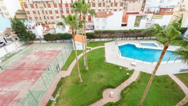 Ein Wohngebiet mit Swimmingpool, Tennisplätzen und Palmen.