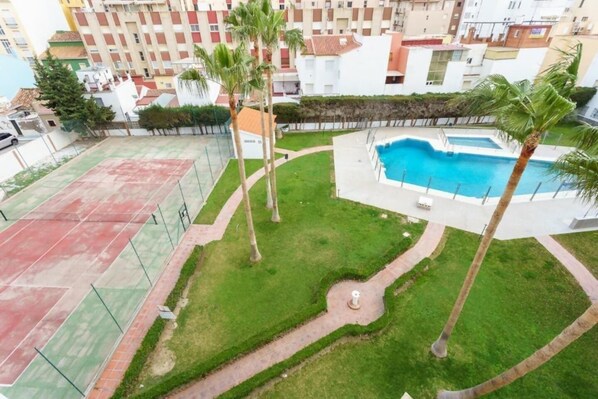 Ein Wohngebiet mit Swimmingpool, Tennisplätzen und Palmen.