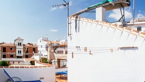 Terraza en la azotea con piscina, tumbonas y un tendedero.