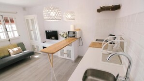 Een moderne keuken met een houten aanrecht, een ingebouwde gootsteen en een magnetron.
