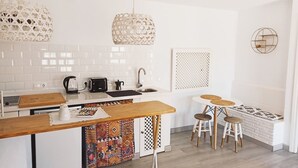 Een moderne keuken met witte kasten, een houten kookeiland en hanglampen.
