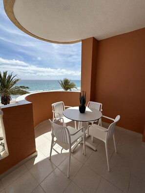 A round table with white chairs and a potted plant, set on a balcony with a view of the ocean. - Hawaii IV 3B - La Manga By WATERMELON (La Manga del Mar Menor)